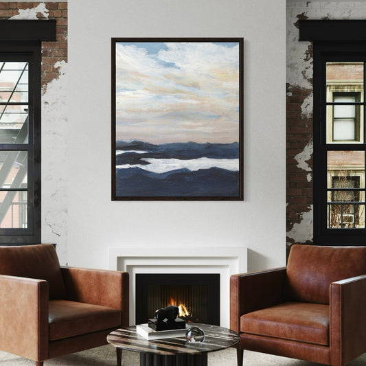 Modern living room with brown leather chairs, a coffee table, and a framed landscape painting on the wall.