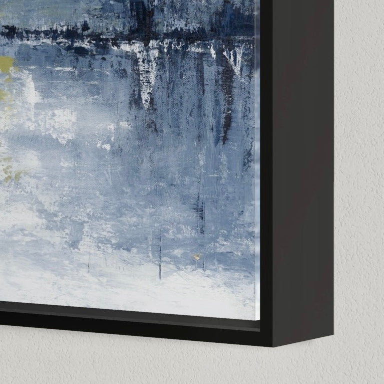 Abstract painting with blue and gray tones in a black frame on a light gray wall.