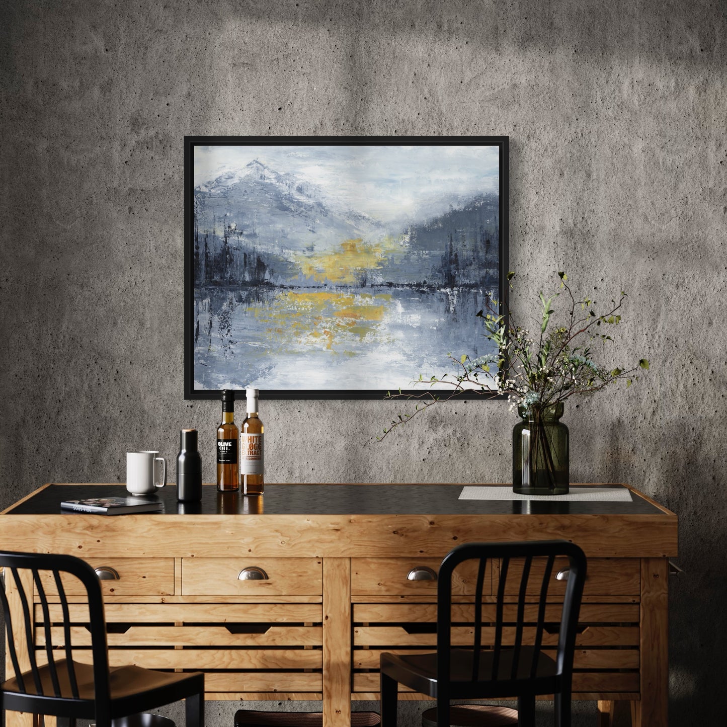 Wooden desk with bottles and a vase against a textured wall with a framed abstract painting.