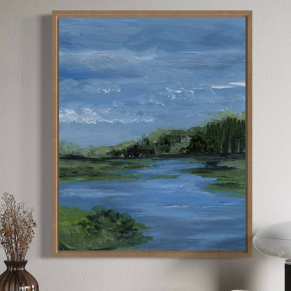 Framed painting of a landscape with a river and trees on a wall.