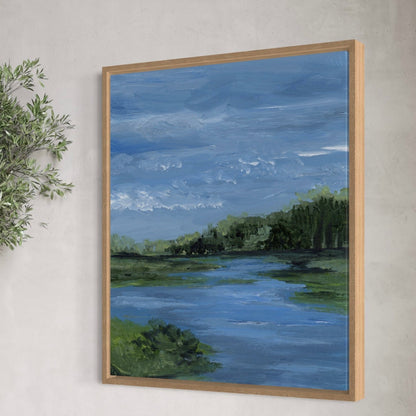 Framed painting of a landscape with a river and trees on a wall.