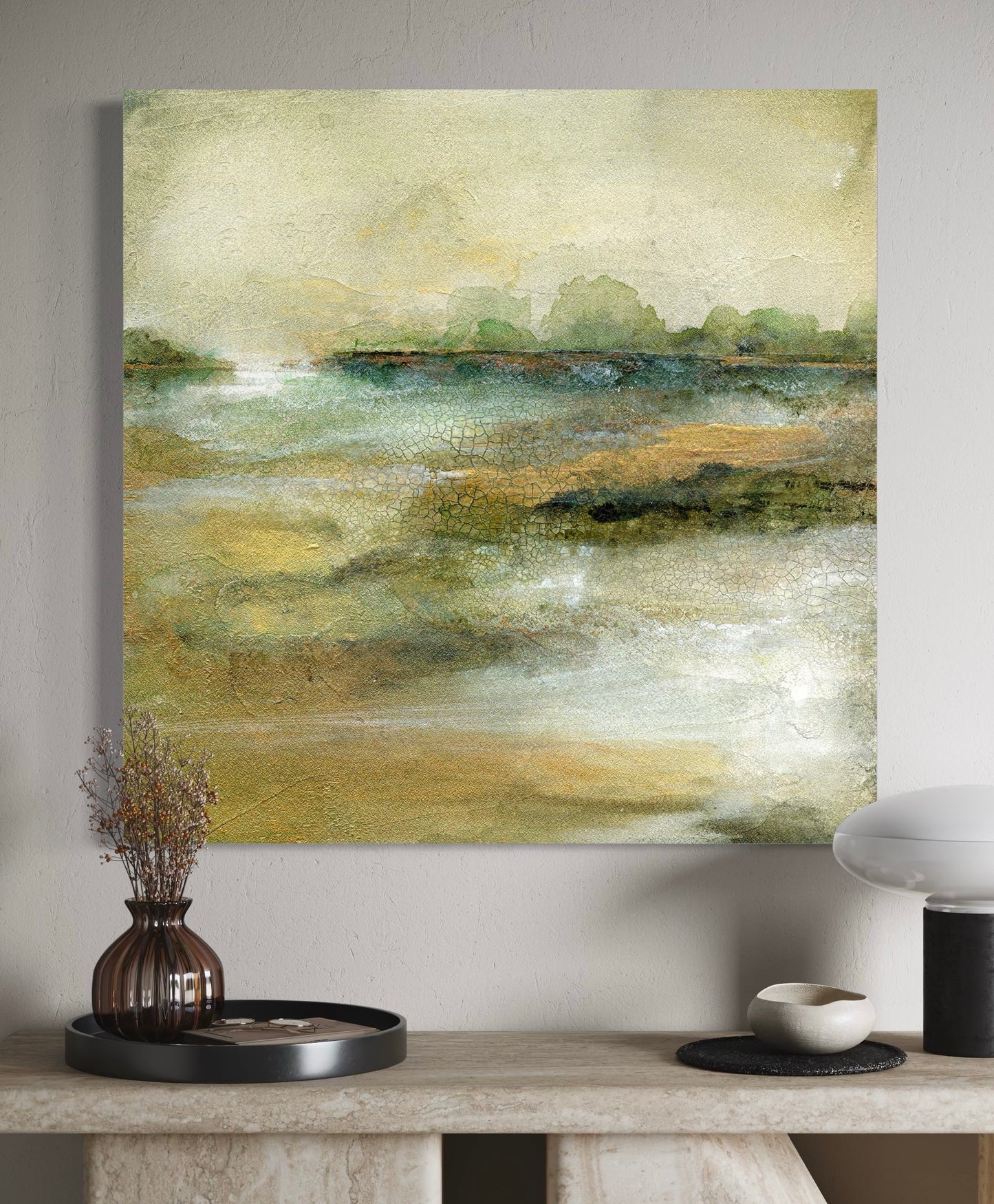 Abstract landscape painting on a wall above a table with decorative items.