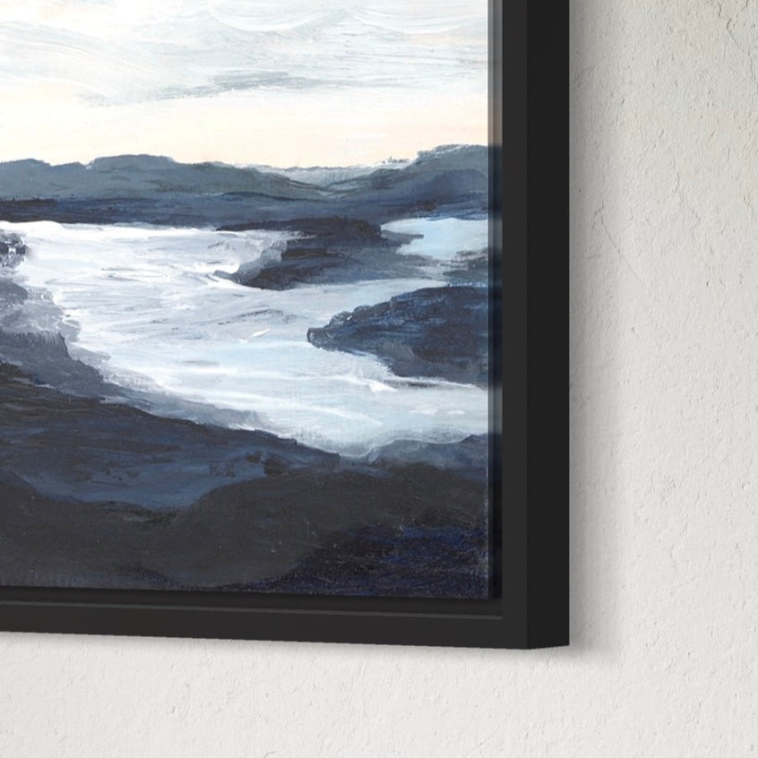 Framed artwork of a landscape with mountains and water on a textured wall.