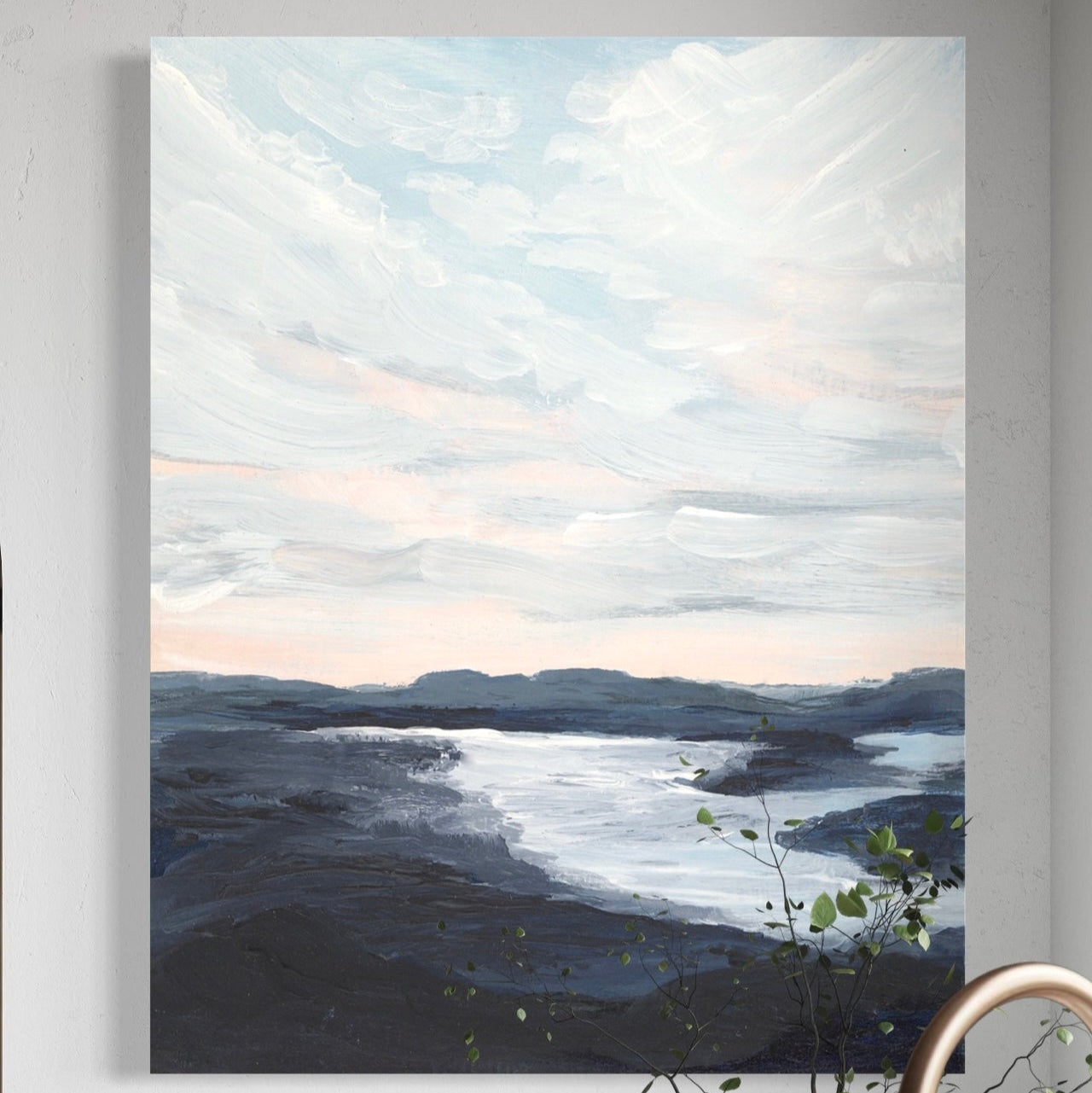 Canvas print of a landscape with mountains and water hanging on a wall above a kitchen sink.