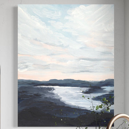 Canvas print of a landscape with mountains and water hanging on a wall above a kitchen sink.