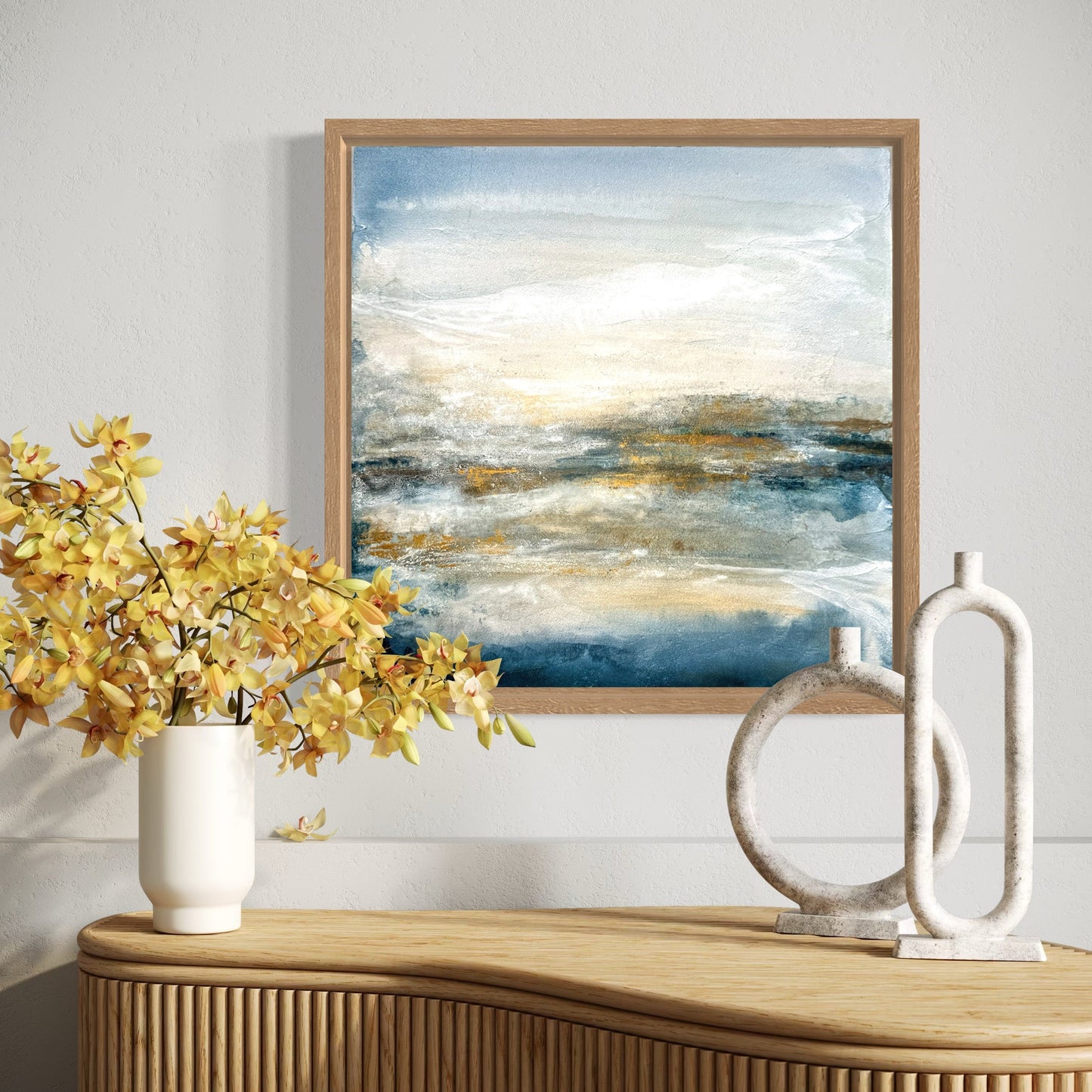 Framed abstract painting on a wall above a wooden console table with decorative items.