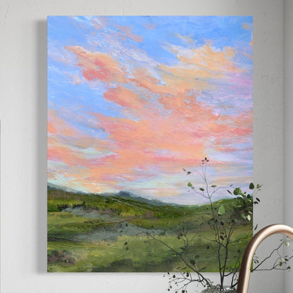 Painting of a landscape with a colorful sky above a kitchen counter.