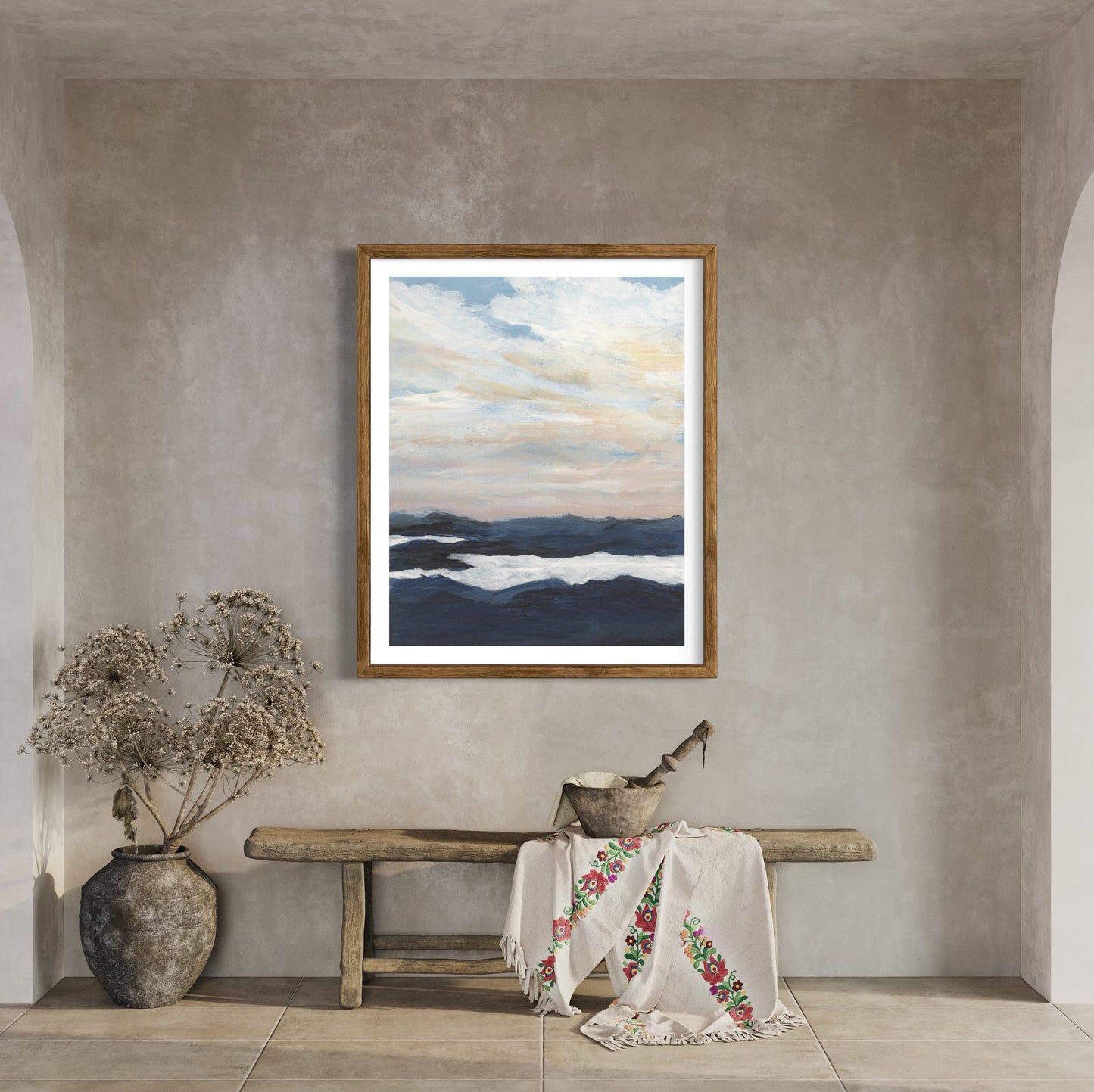 Framed artwork of a landscape with a bench and decorative items in a room.