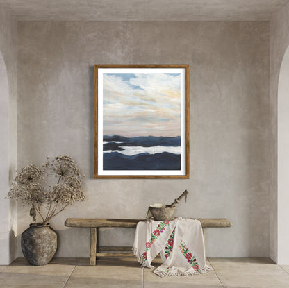 Framed artwork of a landscape with a bench and decorative items in a room.