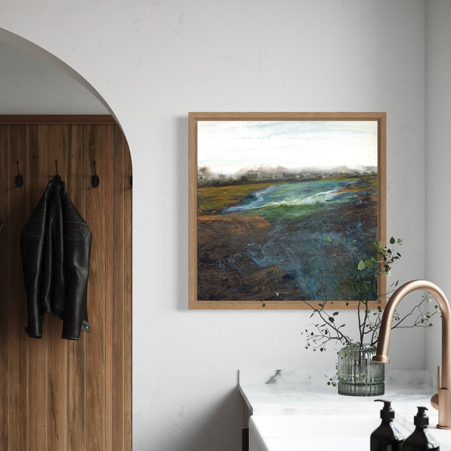 Modern interior with wooden coat rack, framed artwork, and kitchen counter.