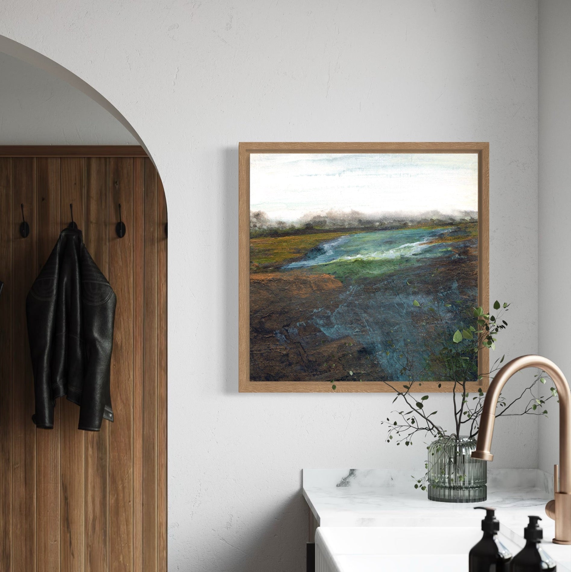 Modern interior with wooden coat rack, framed artwork, and kitchen counter.