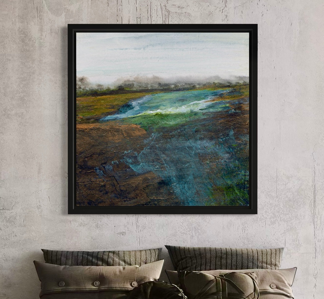 Framed landscape painting on a textured wall above a sofa.