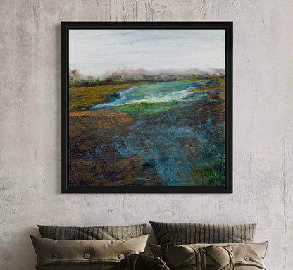 Framed landscape painting on a textured wall above a sofa.