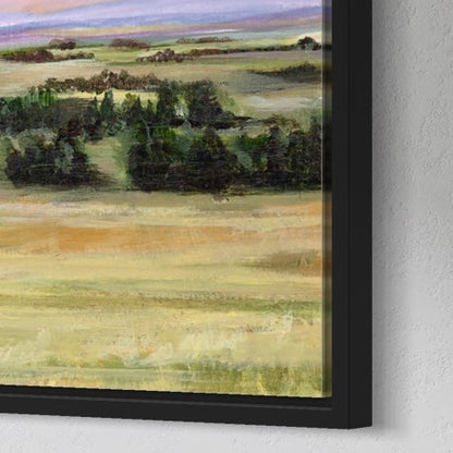 Framed landscape painting of a field with trees on a white wall