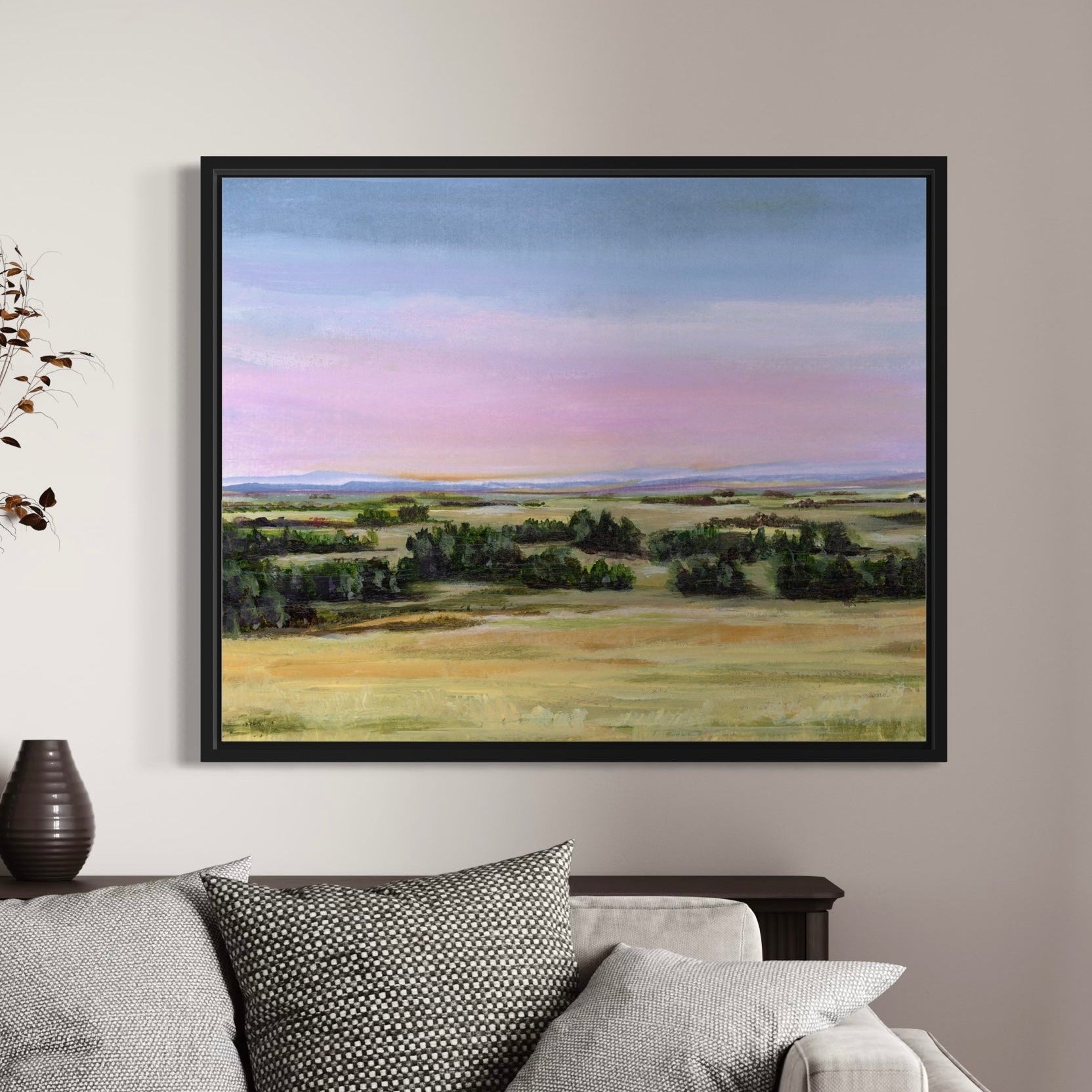 Framed landscape painting on a wall above a sofa