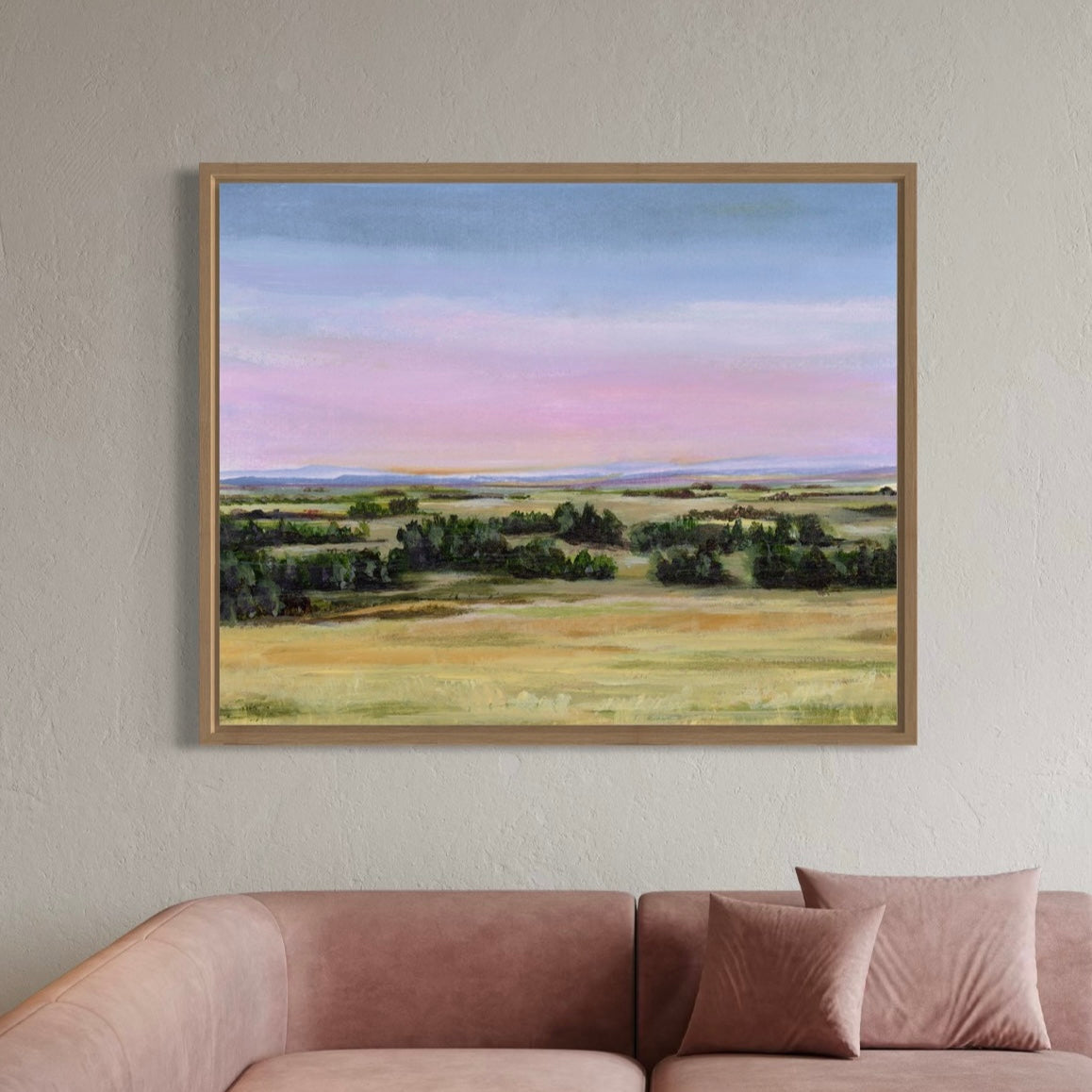 Framed landscape painting on a wall above a sofa