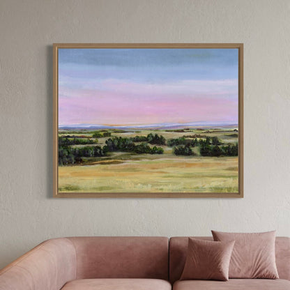 Framed landscape painting on a wall above a sofa