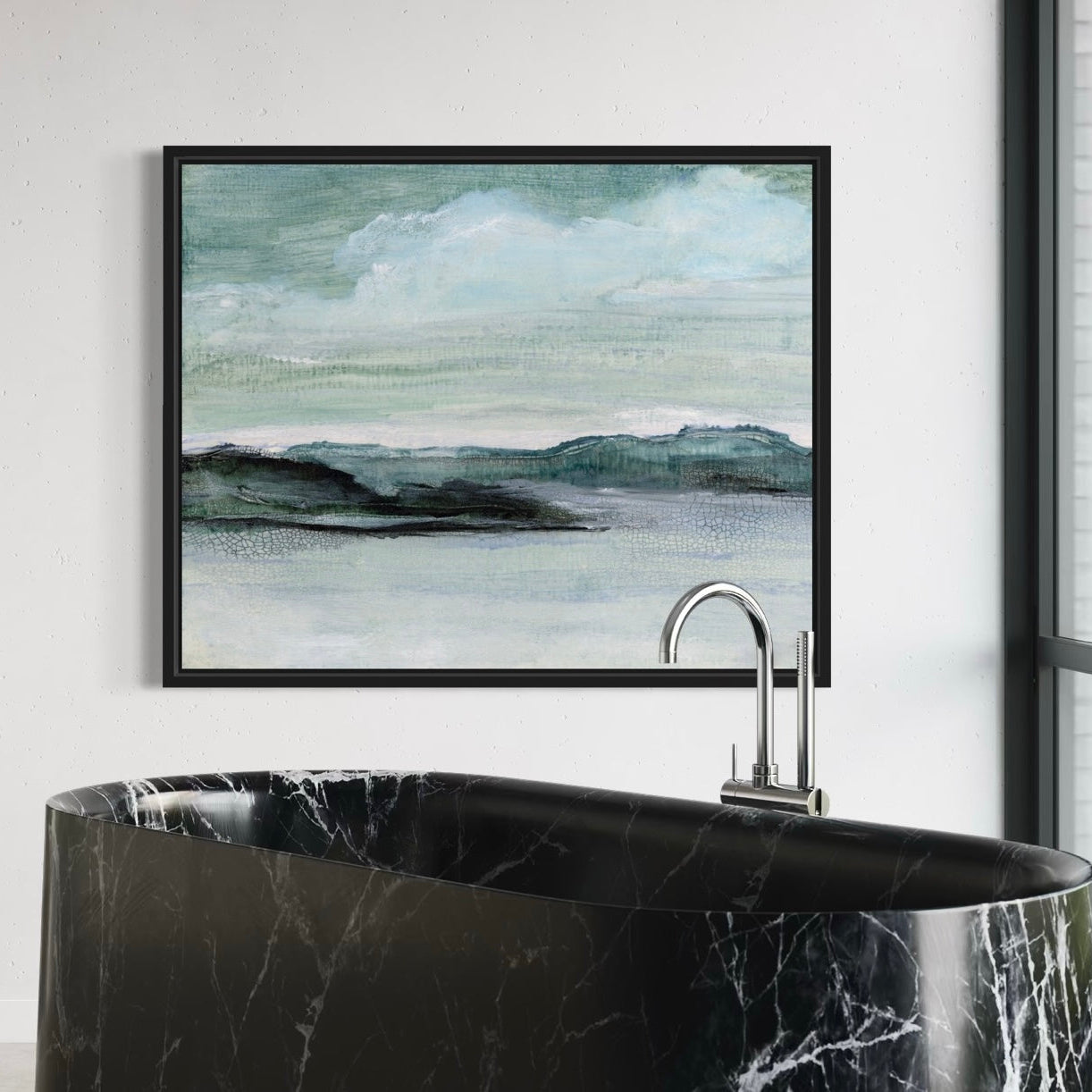 Framed landscape painting above a black marble bathtub.