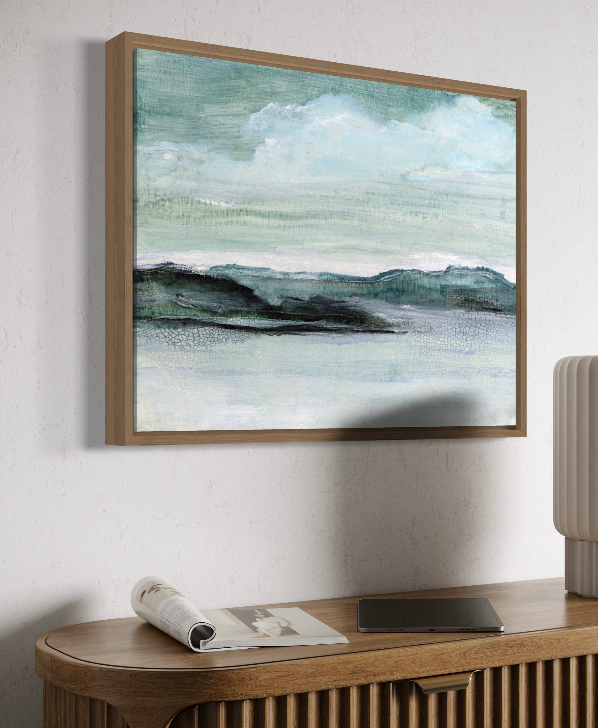 Framed abstract painting on a wall above a wooden console table.