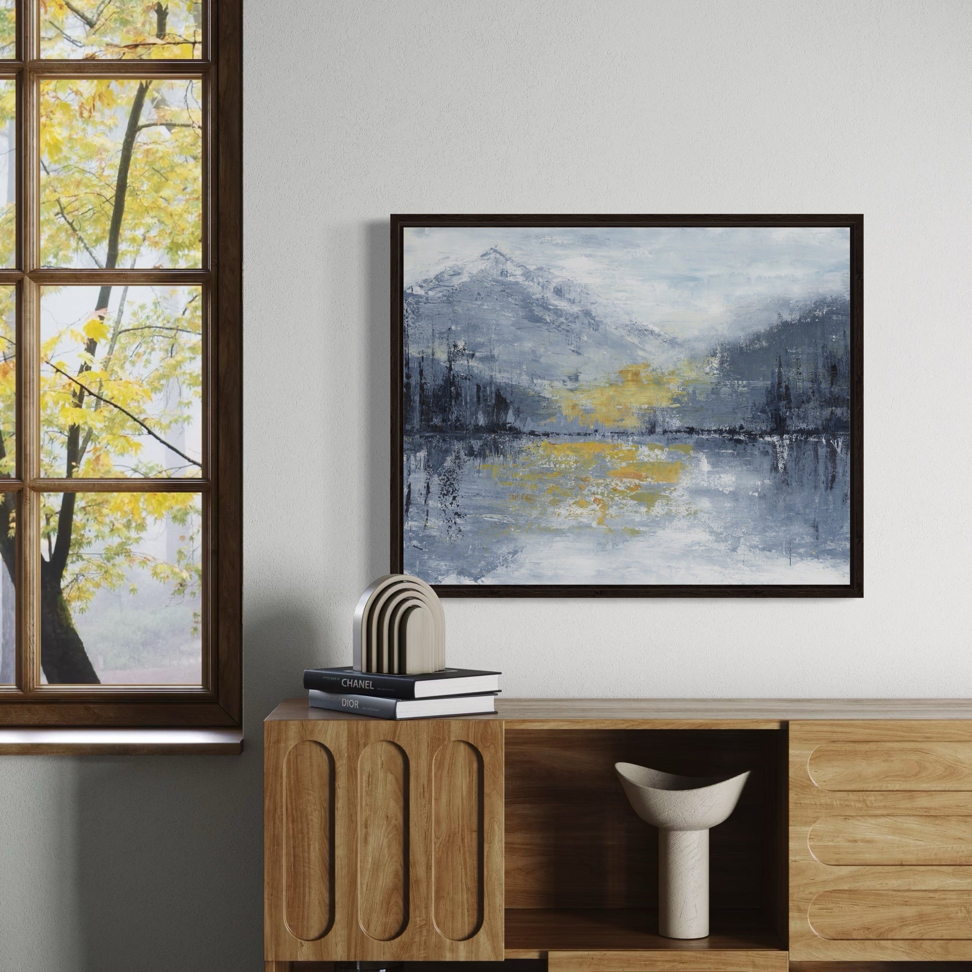 Framed abstract art on a wall with a wooden cabinet below