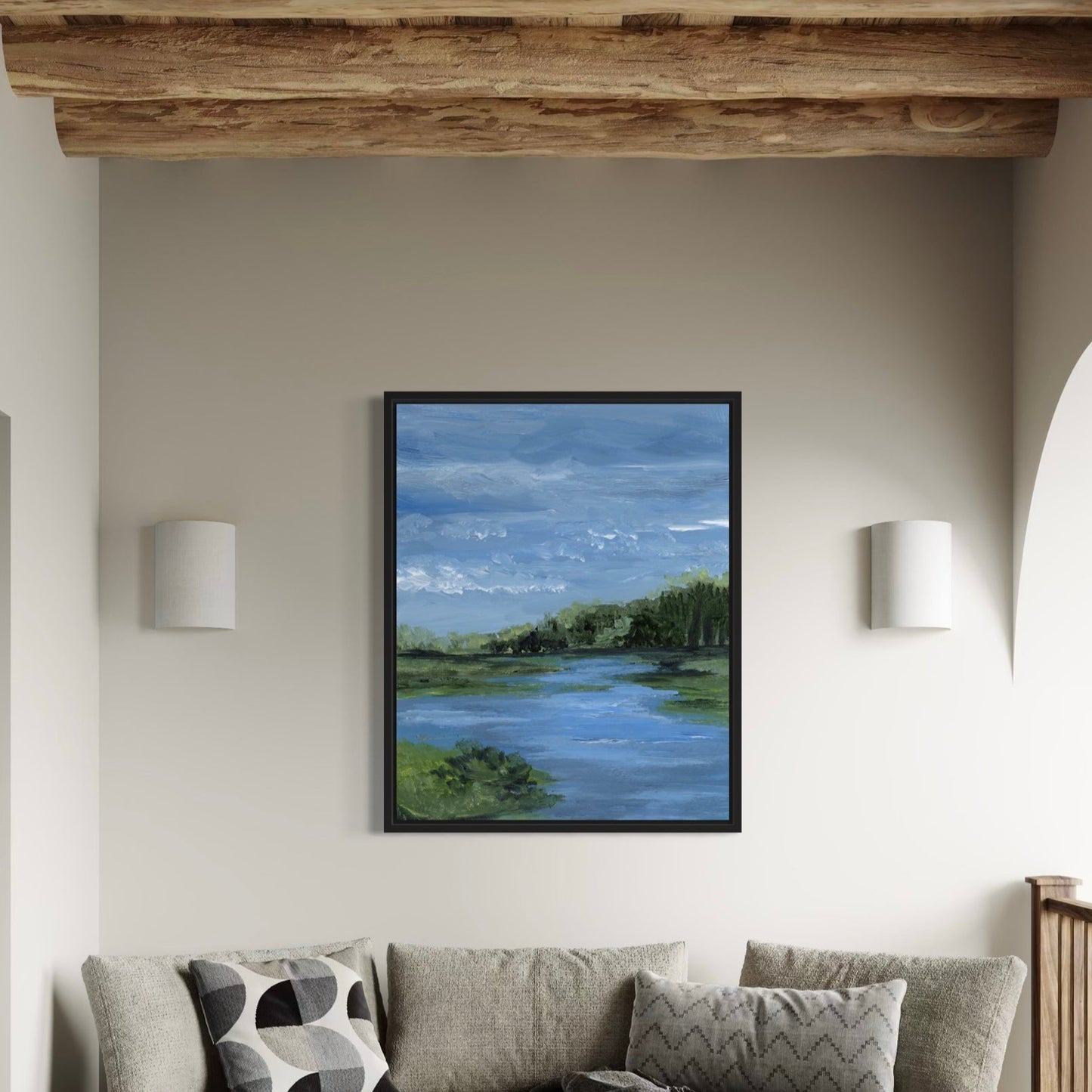 Framed artwork above a sofa in a living room with wooden beams.