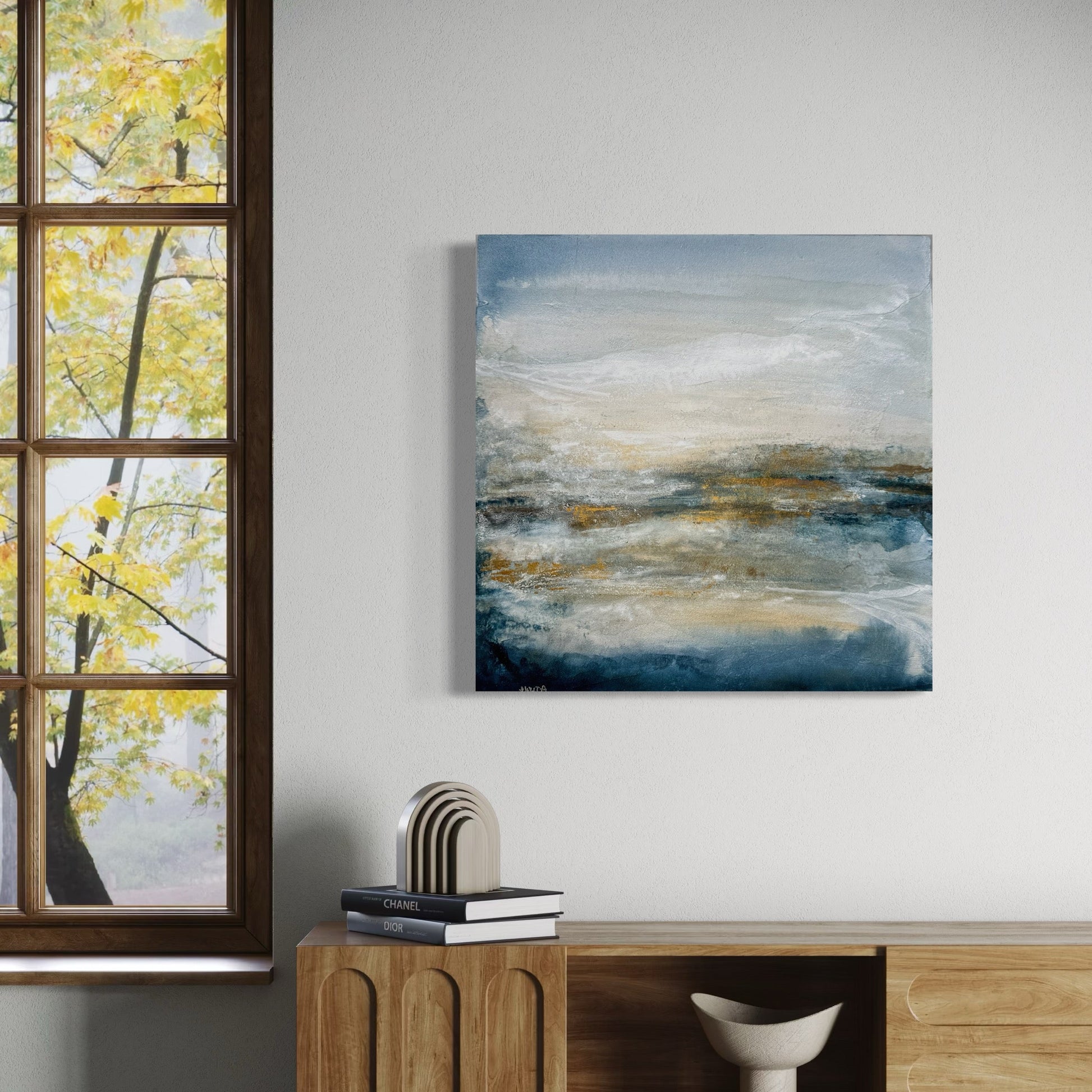 Room interior with abstract painting on the wall, wooden cabinet, and books.