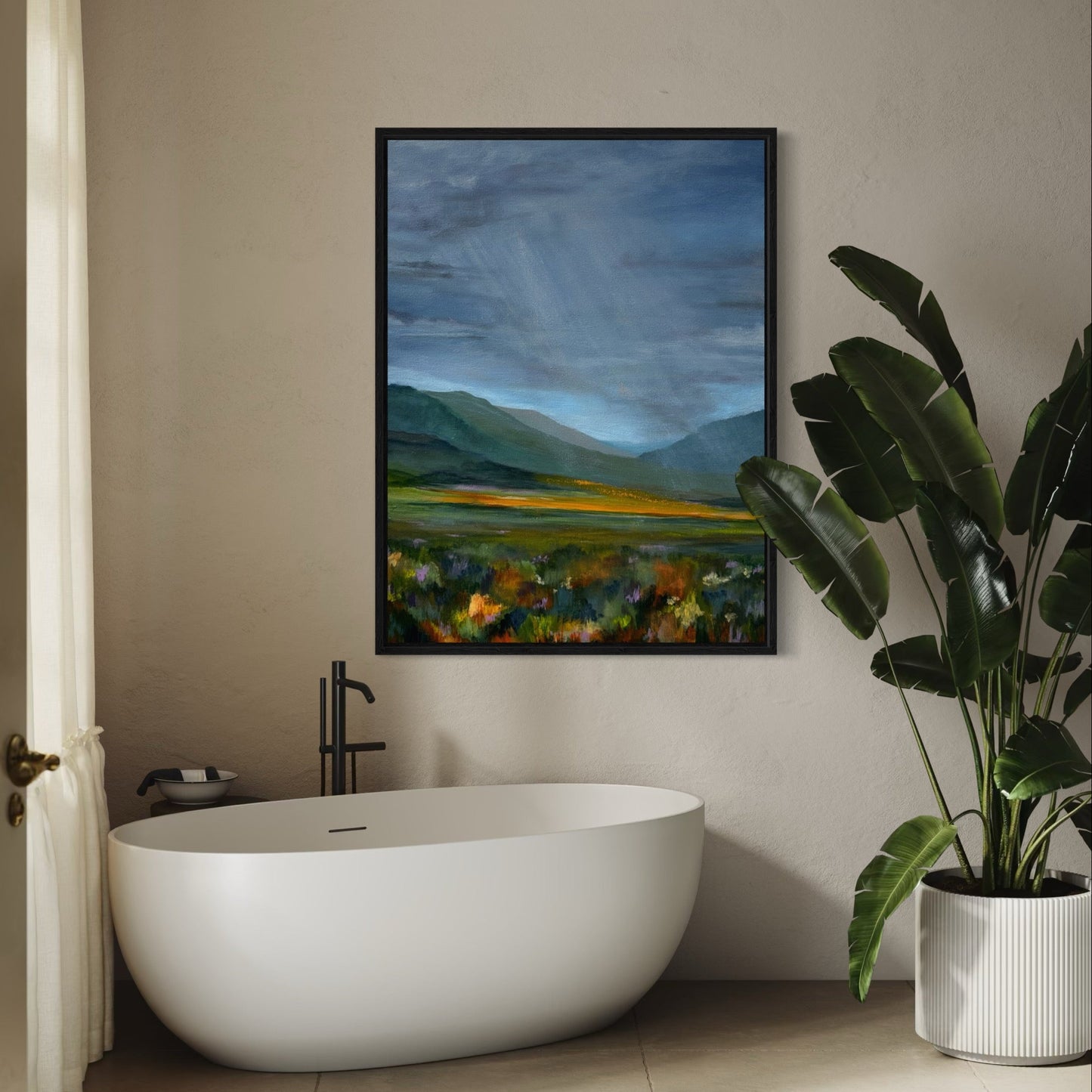 Bathroom with a freestanding bathtub, plant, and wall art of a mountain landscape.